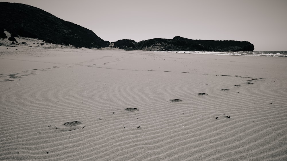 a black and white photo of footprints in the sand