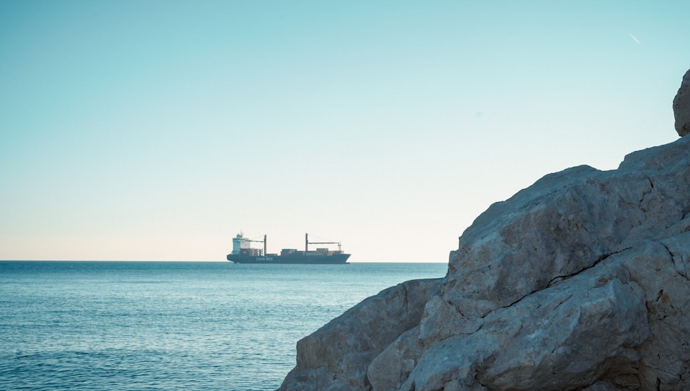 a large cargo ship in the distance off the coast