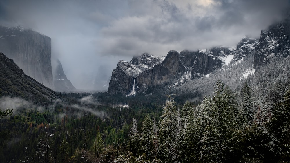 a view of a mountain range with trees in the foreground