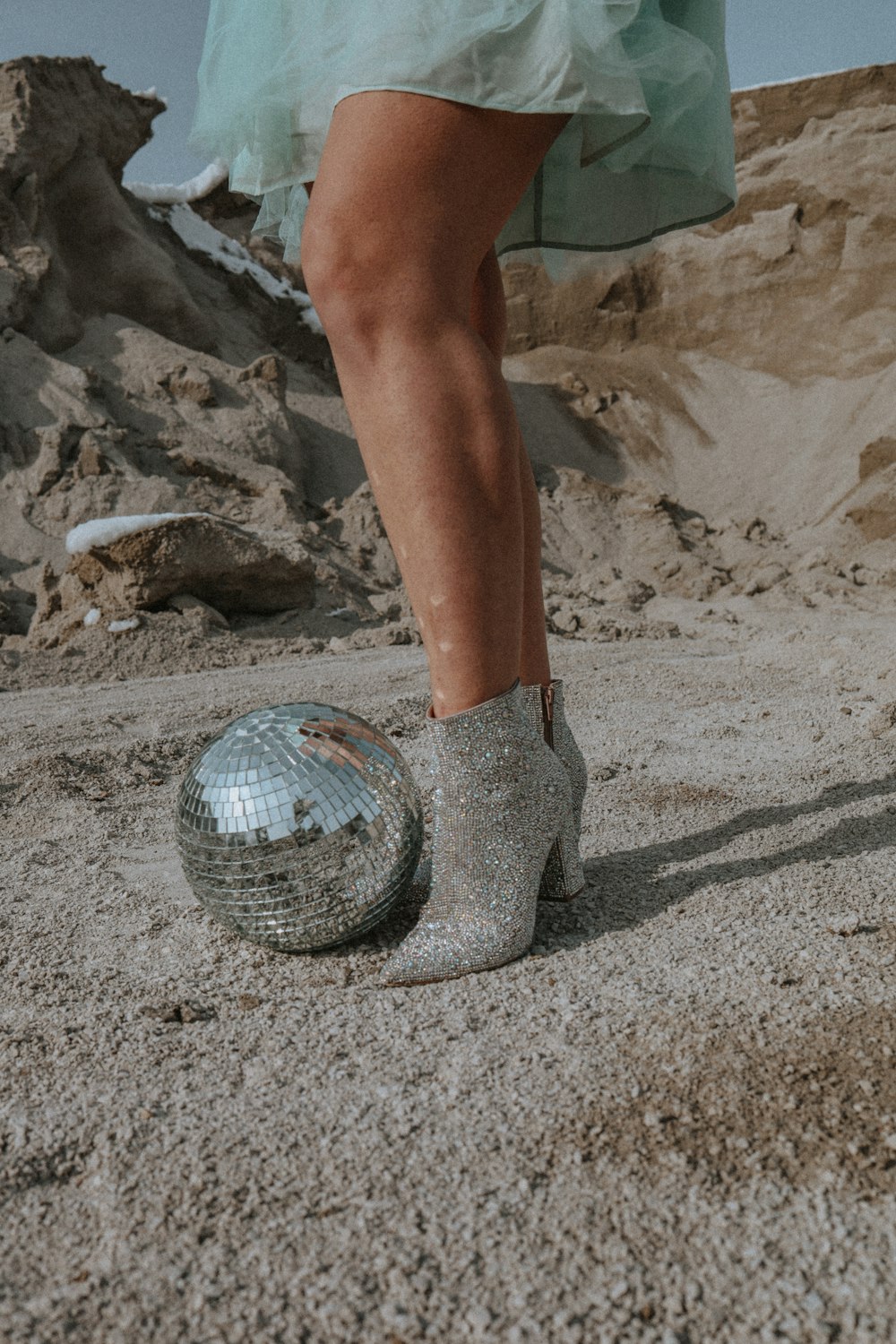 a woman's legs in high heels and a disco ball
