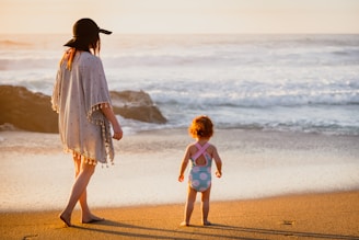 A family wrapped in colorful Marea ponchos, laughing on a sunny beach