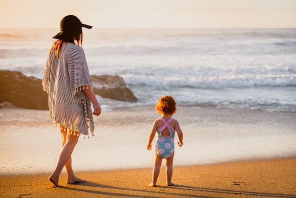 A family wrapped in colorful Marea ponchos, laughing on a sunny beach