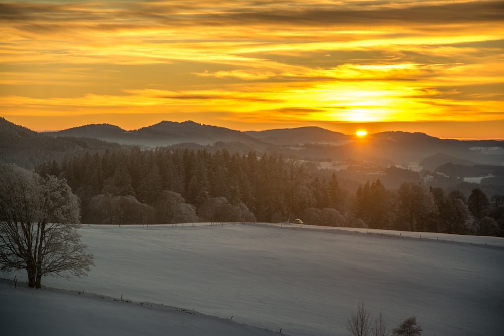 Le soleil se couche sur un paysage enneigé