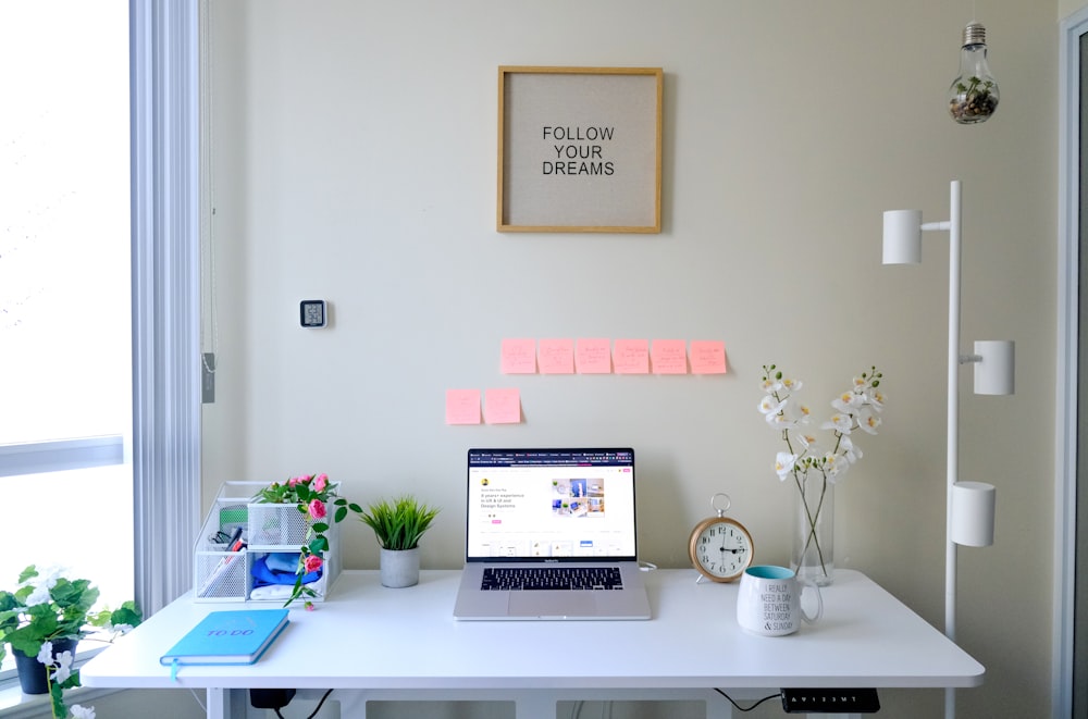 a laptop computer sitting on top of a white desk