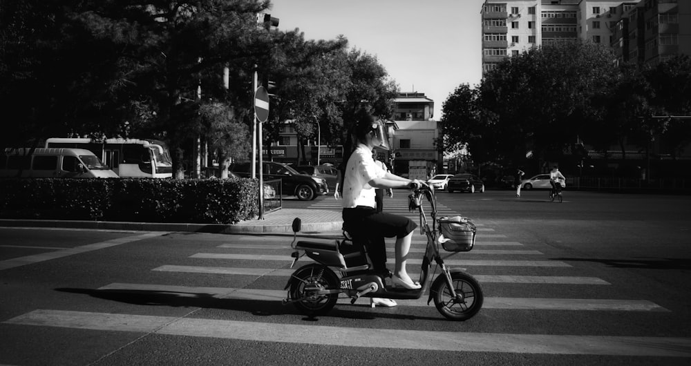 a person riding a scooter on a city street