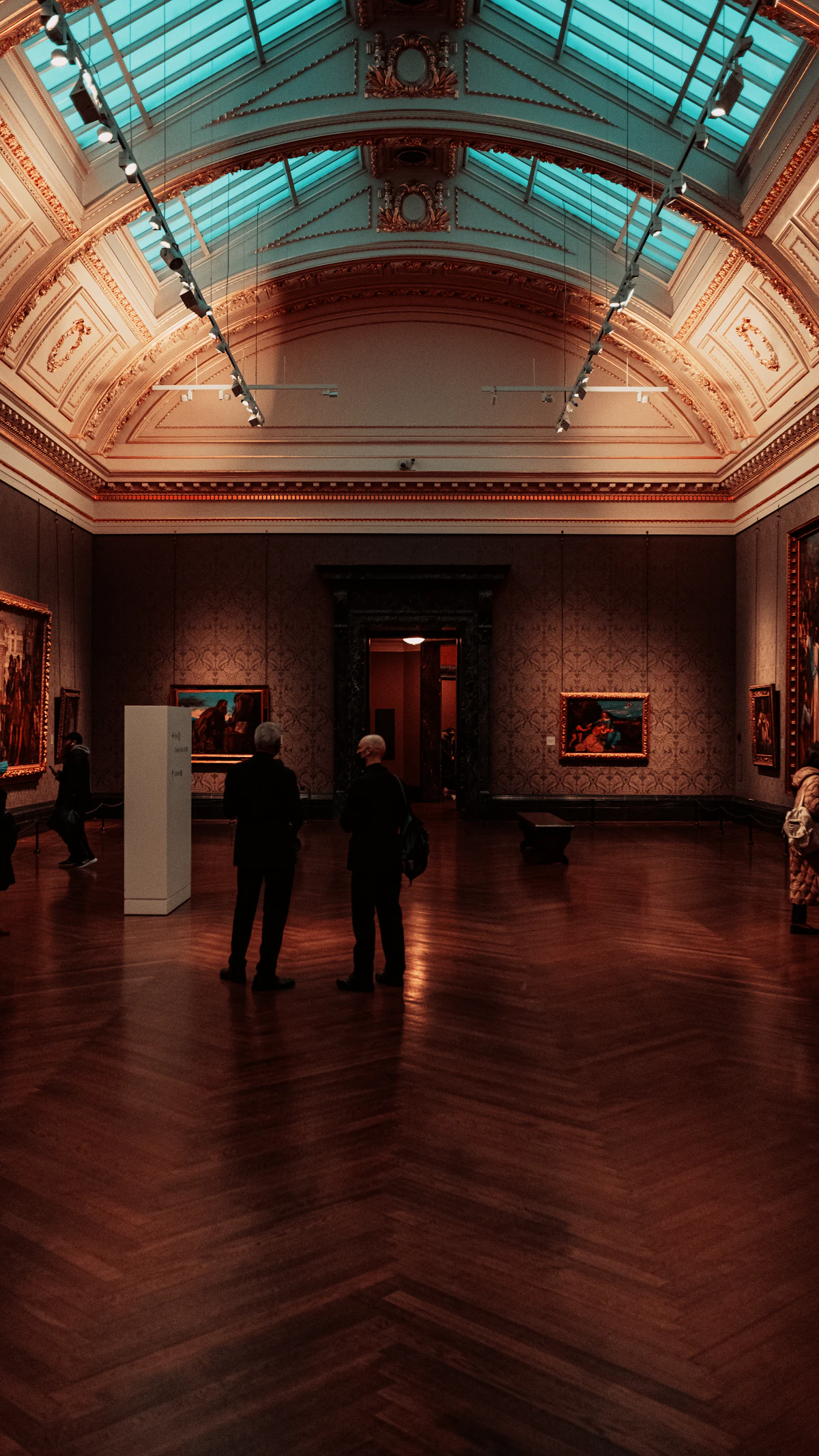 Gallery room, deep-toned walls. Illustrative editorial image, not a photograph of Printers Row Gallery.