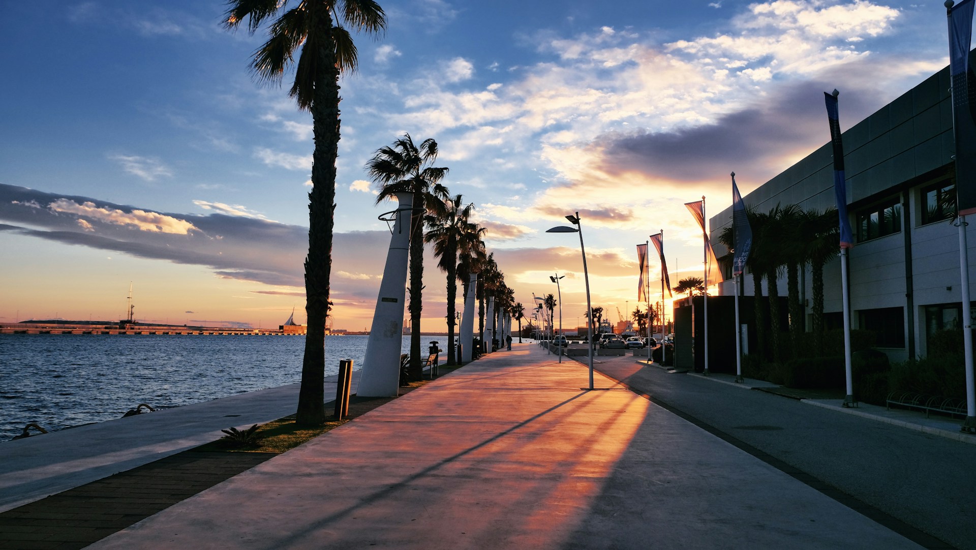 the sun is setting over the water and palm trees