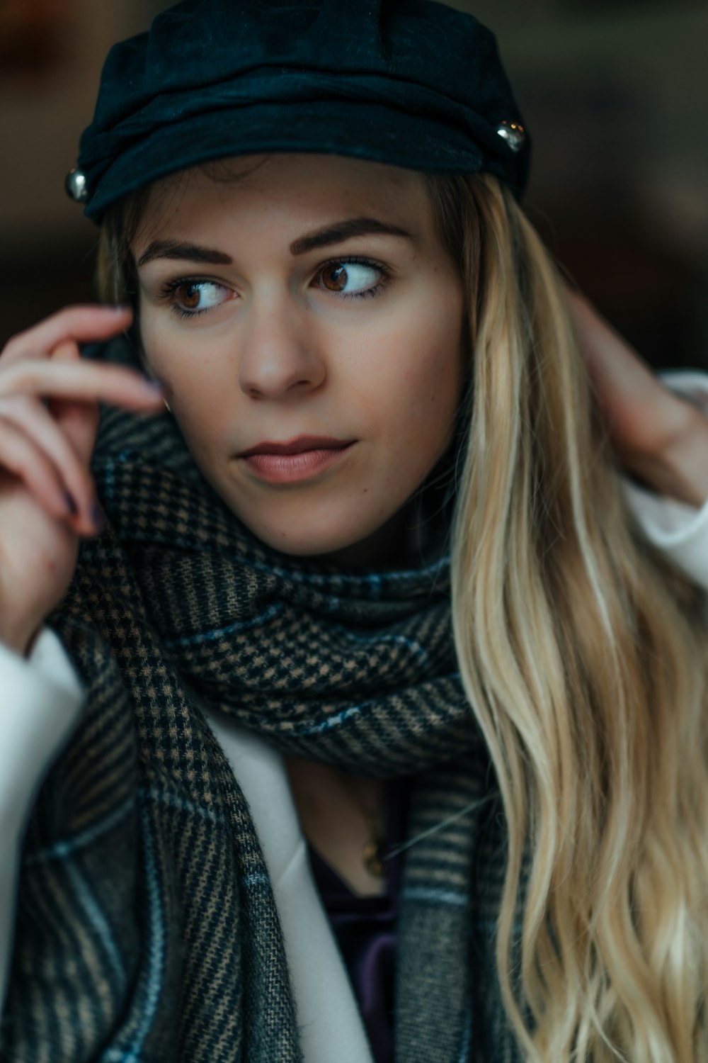 a woman wearing a hat and scarf posing for a picture