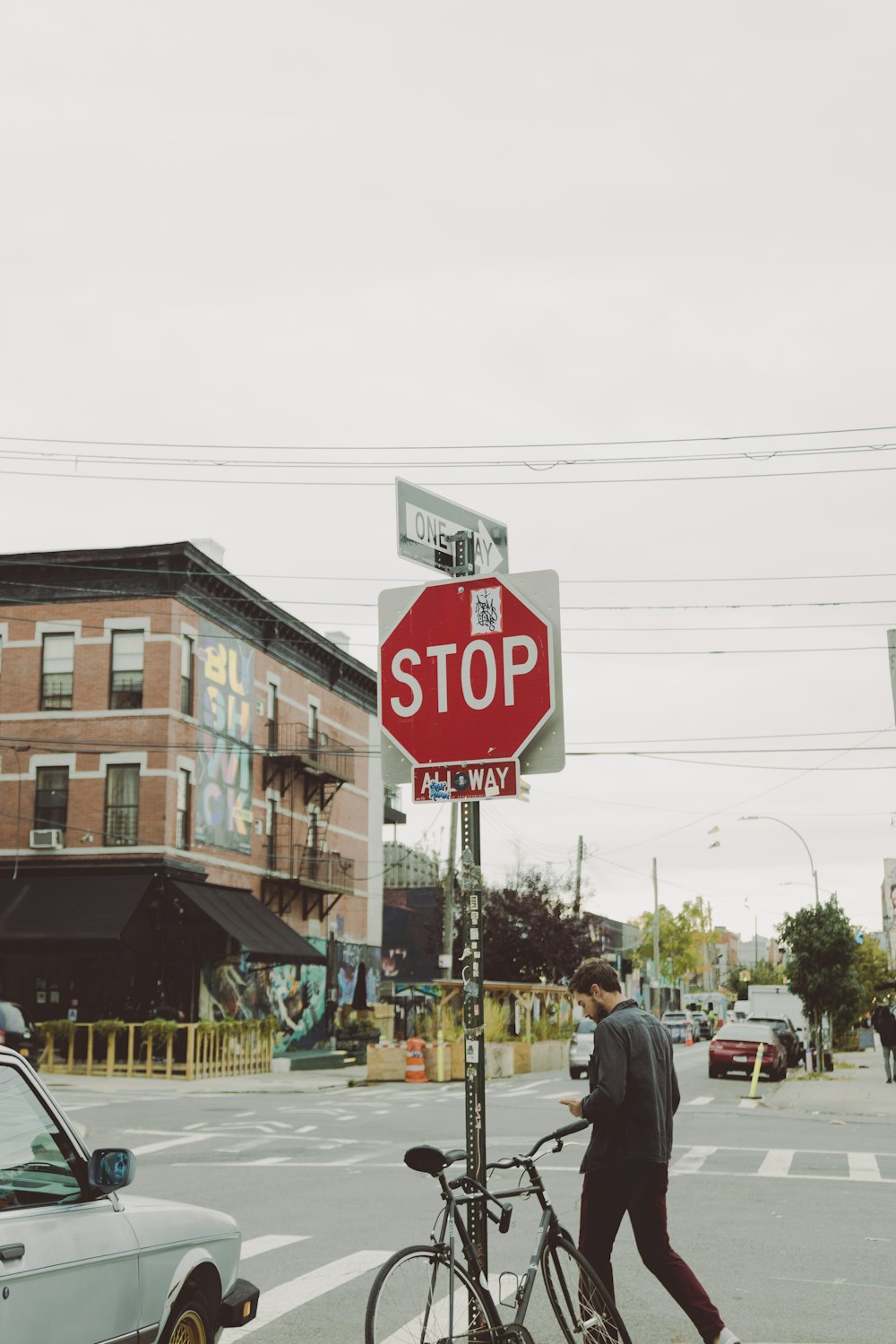 a man walking a bike past a stop sign