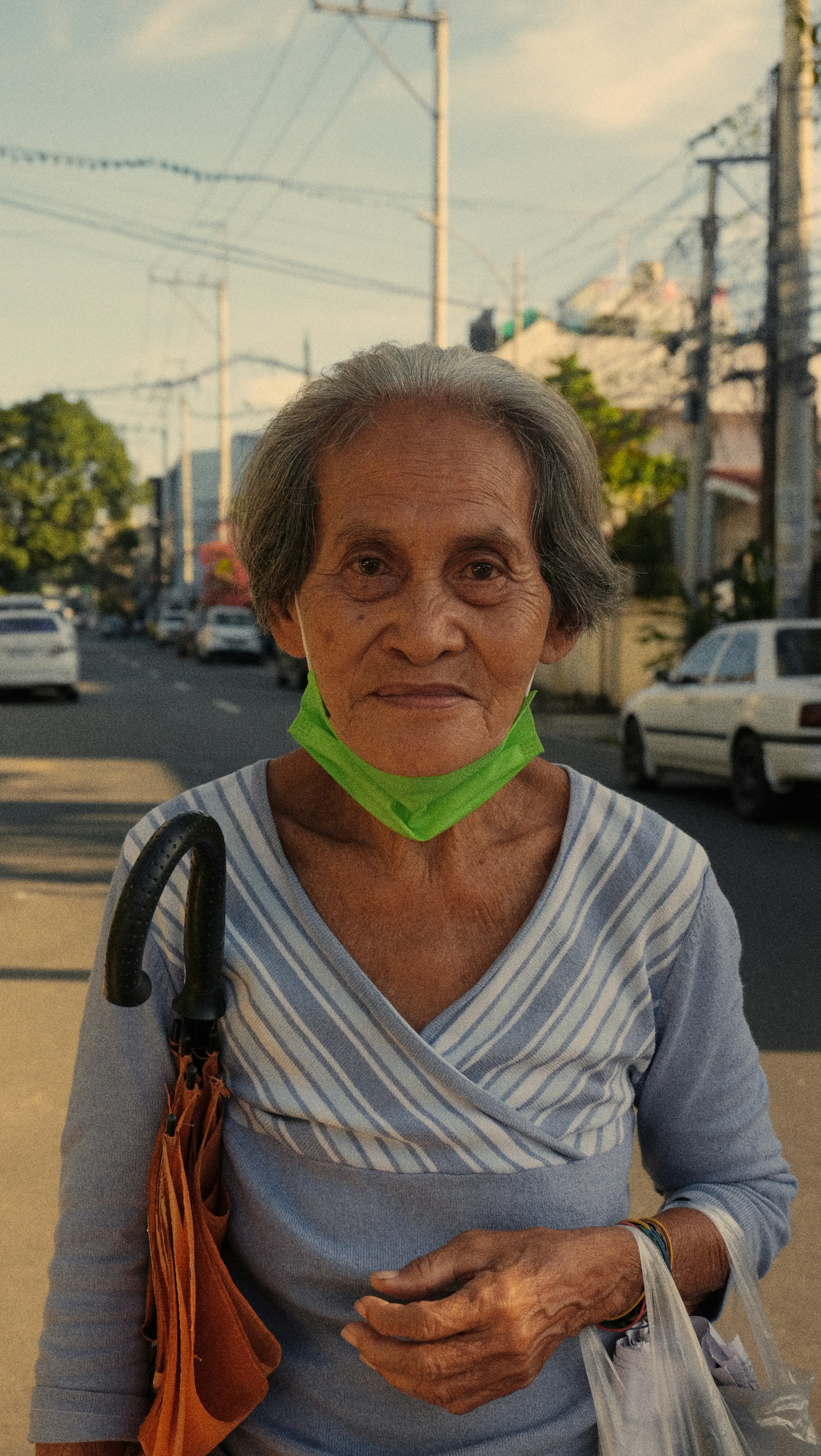 eine alte Frau mit grünem Kragen am Hals