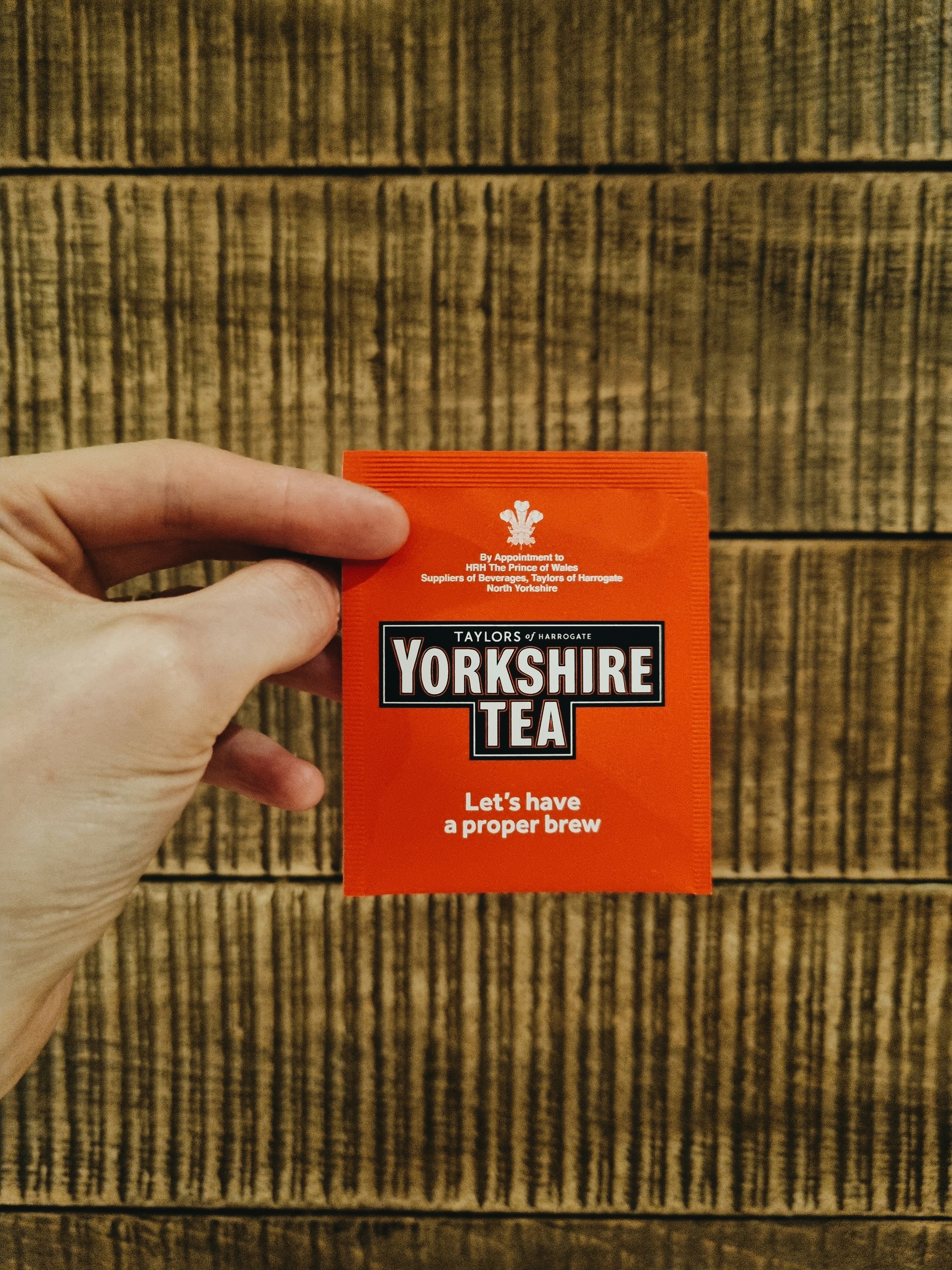 a person holding up a yorkshire tea packet