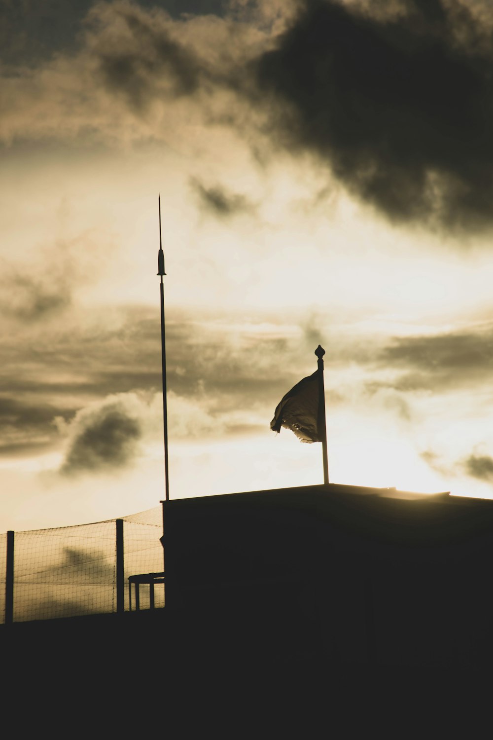 a flag on top of a building under a cloudy sky