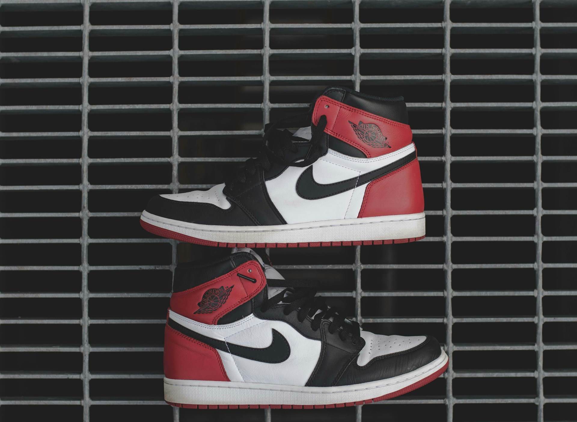 Bold display of Versace and Louis Vuitton sneakers arranged on cracked concrete with basketball court lines in the background.