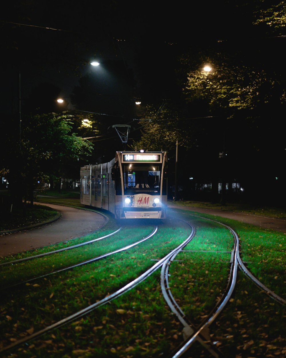 a trolley car traveling down the tracks at night