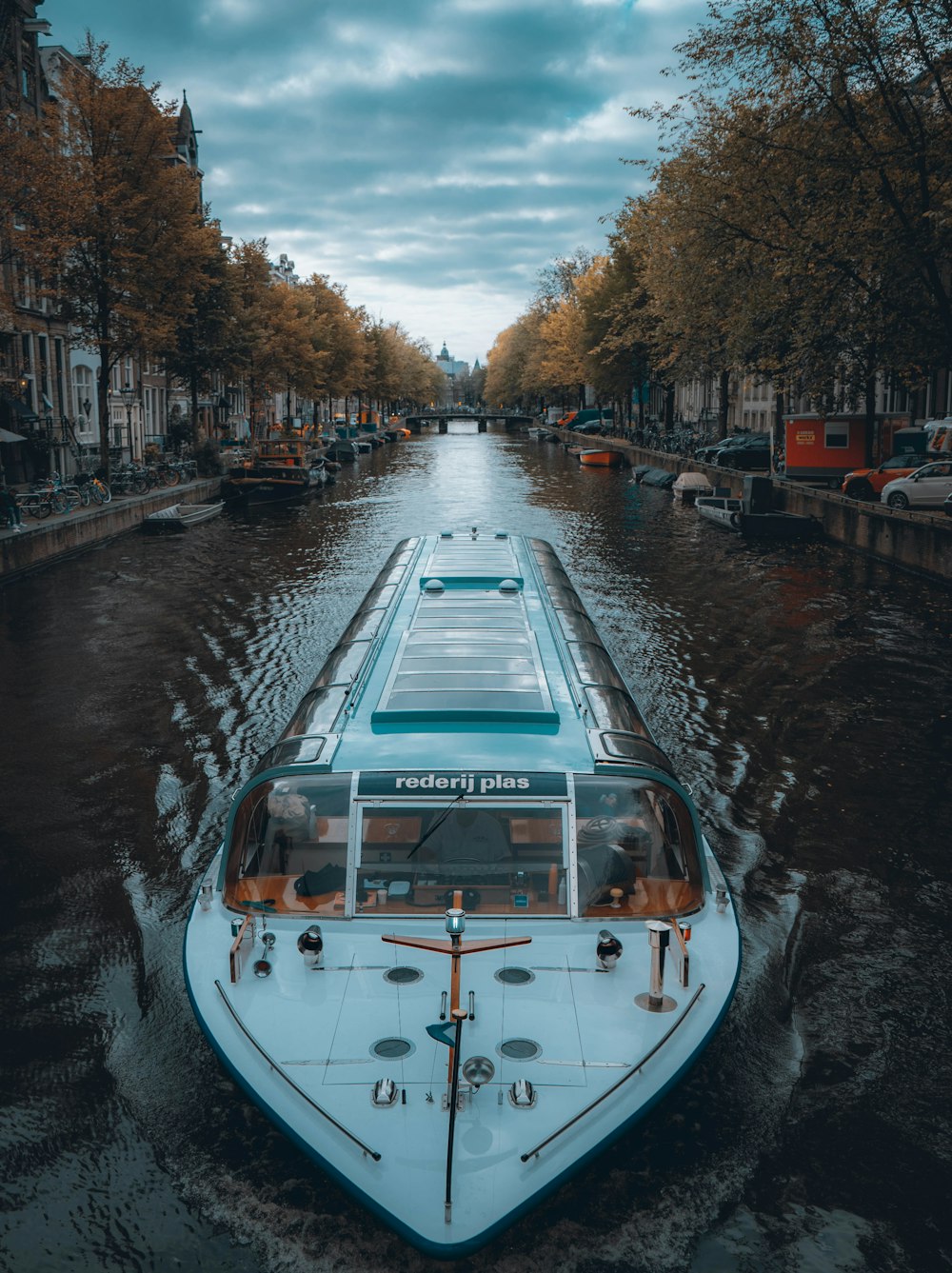 a boat traveling down a river next to tall buildings