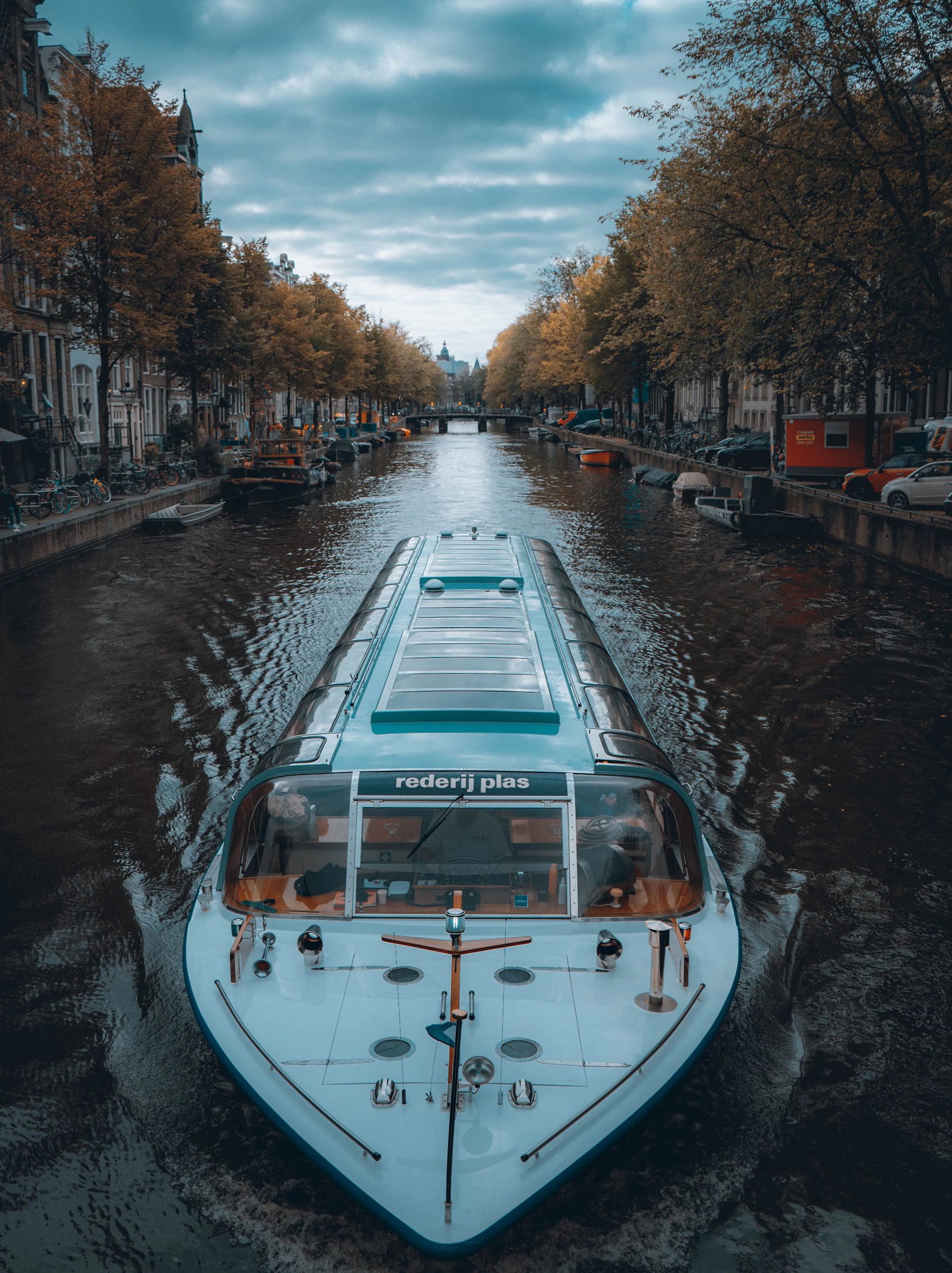 a boat traveling down a river next to tall buildings