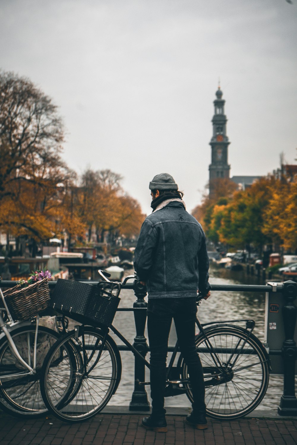 a man standing next to a bike on a sidewalk