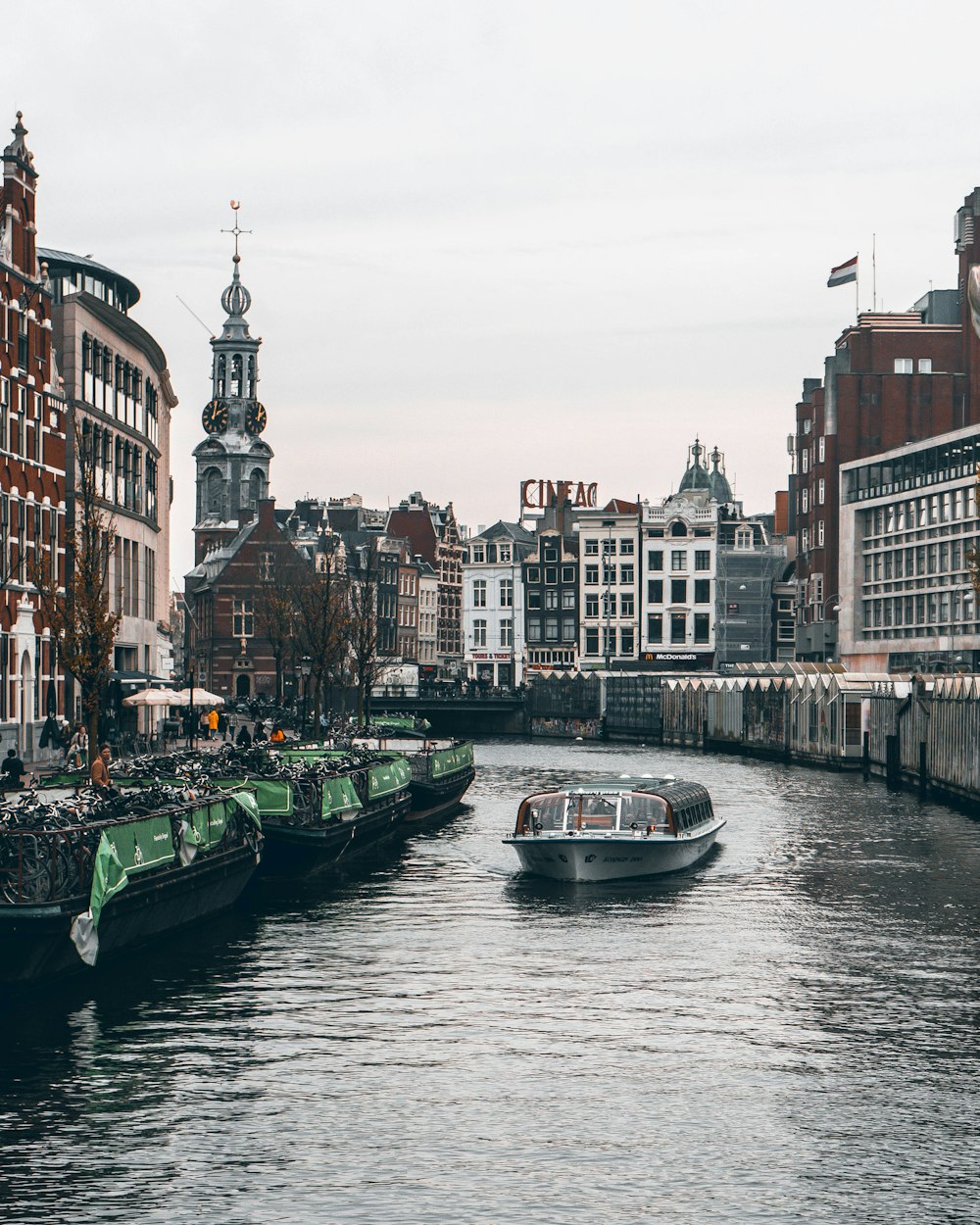 a boat traveling down a river next to tall buildings