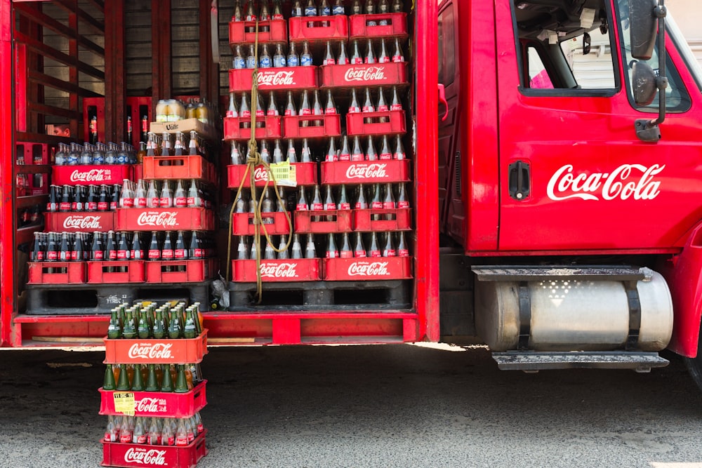 a red coca - cola truck filled with bottles of soda