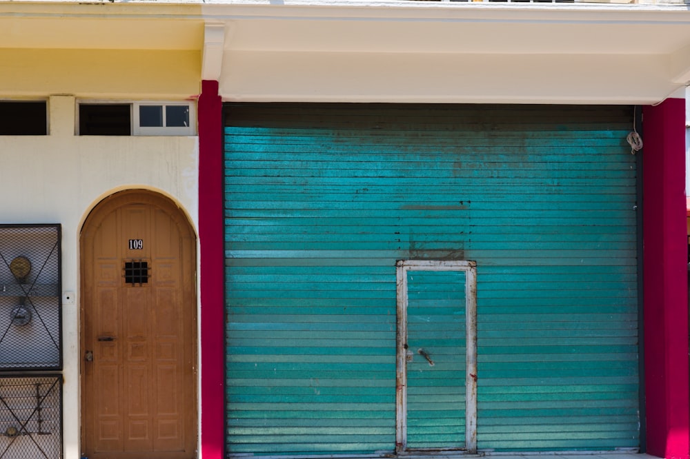 a blue garage door and a brown door in front of a building