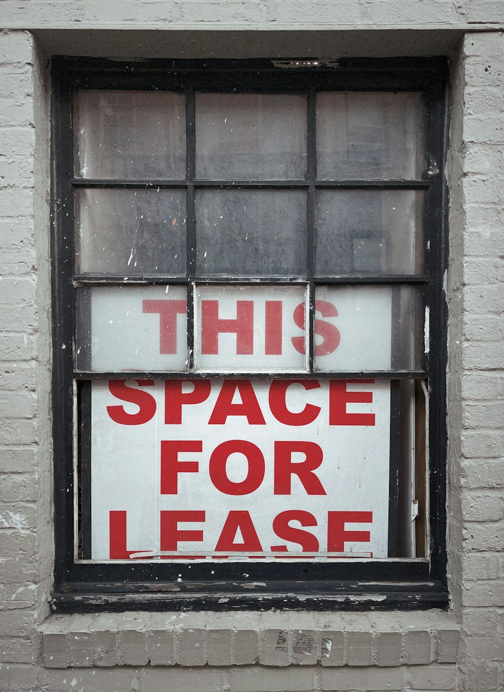 a window with a sign that says this space for ease