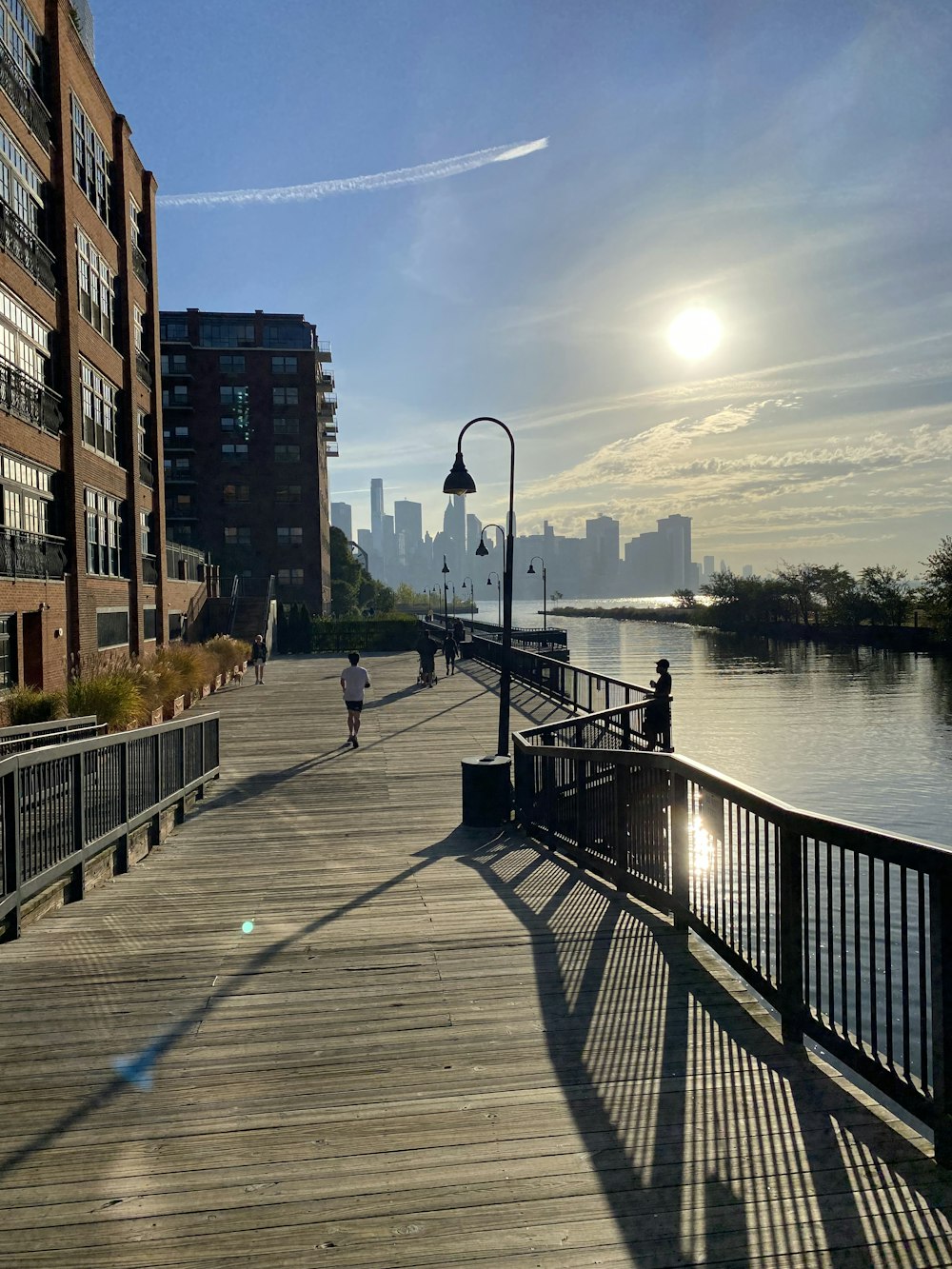 a person walking down a wooden walkway next to a body of water