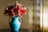 Orange lilies beside handmade pottery on a sunlit wooden table, evoking a peaceful artisan moment.