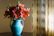 Orange lilies beside handmade pottery on a sunlit wooden table, evoking a peaceful artisan moment.