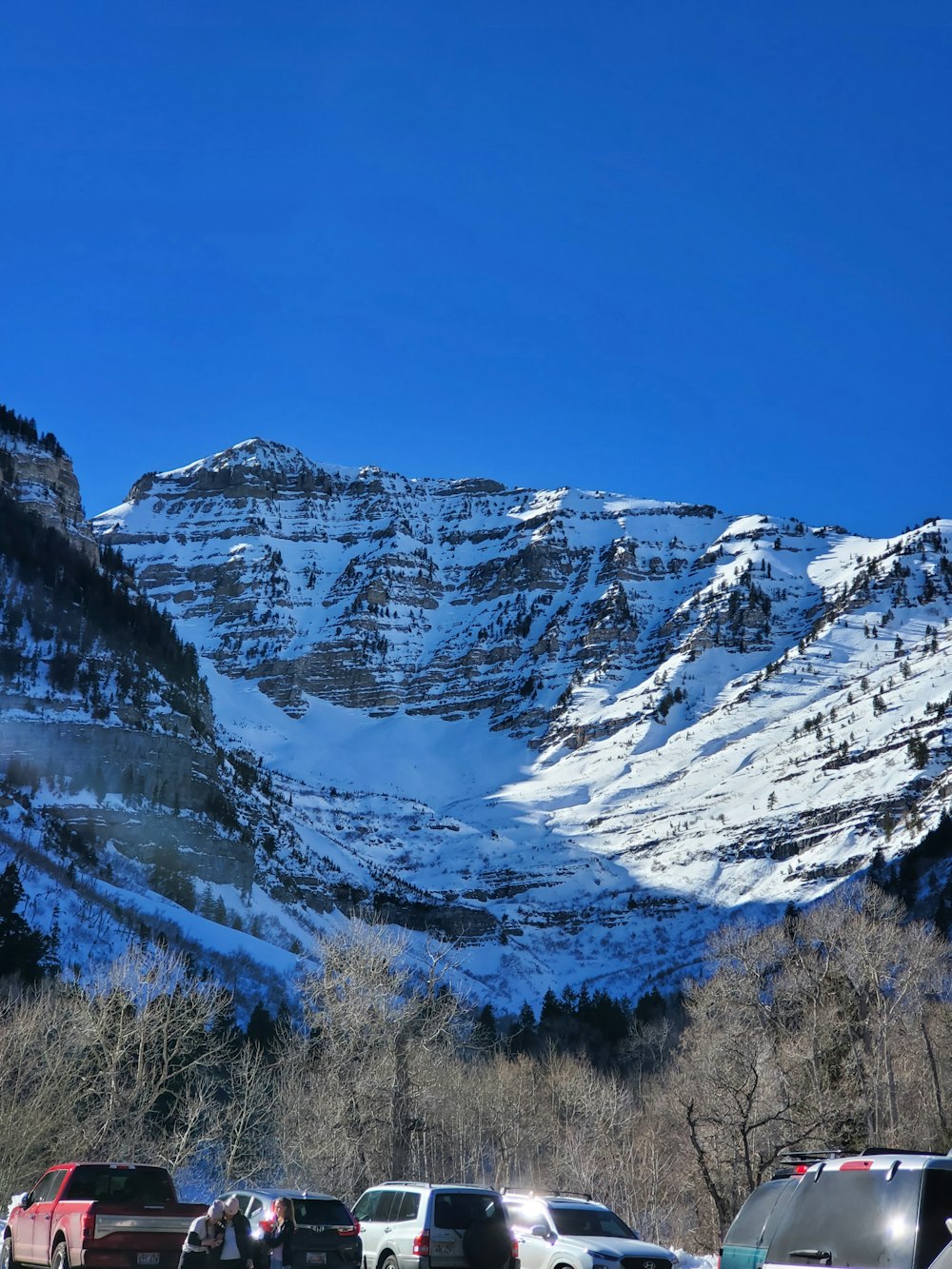 cars parked in a parking lot in front of a mountain