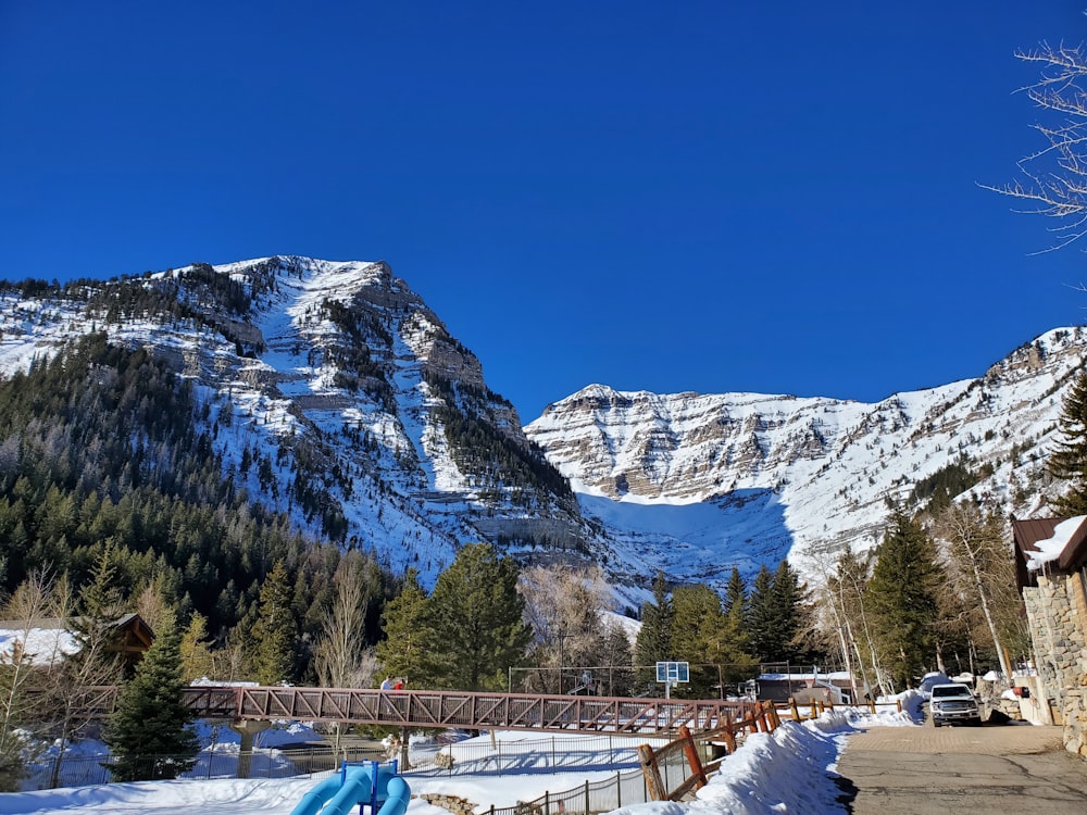 a mountain covered in snow next to a road