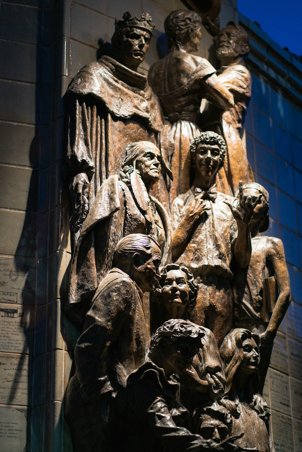a statue of a group of people in front of a building
