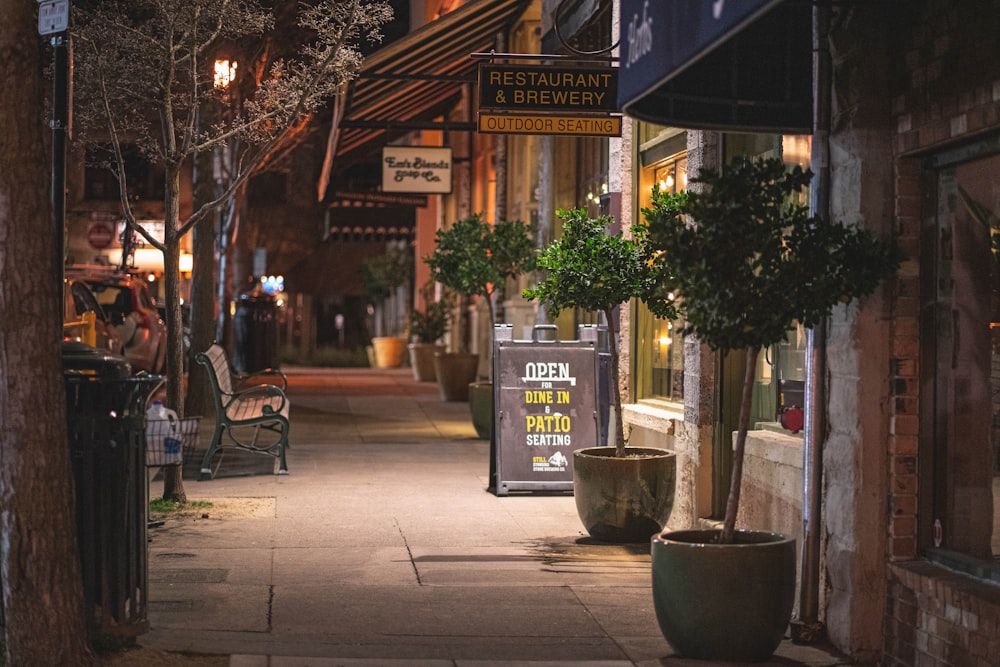 a sidewalk at night with a sign on it