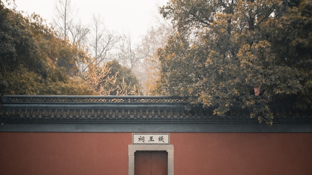 a red building with a red door and chinese writing on it