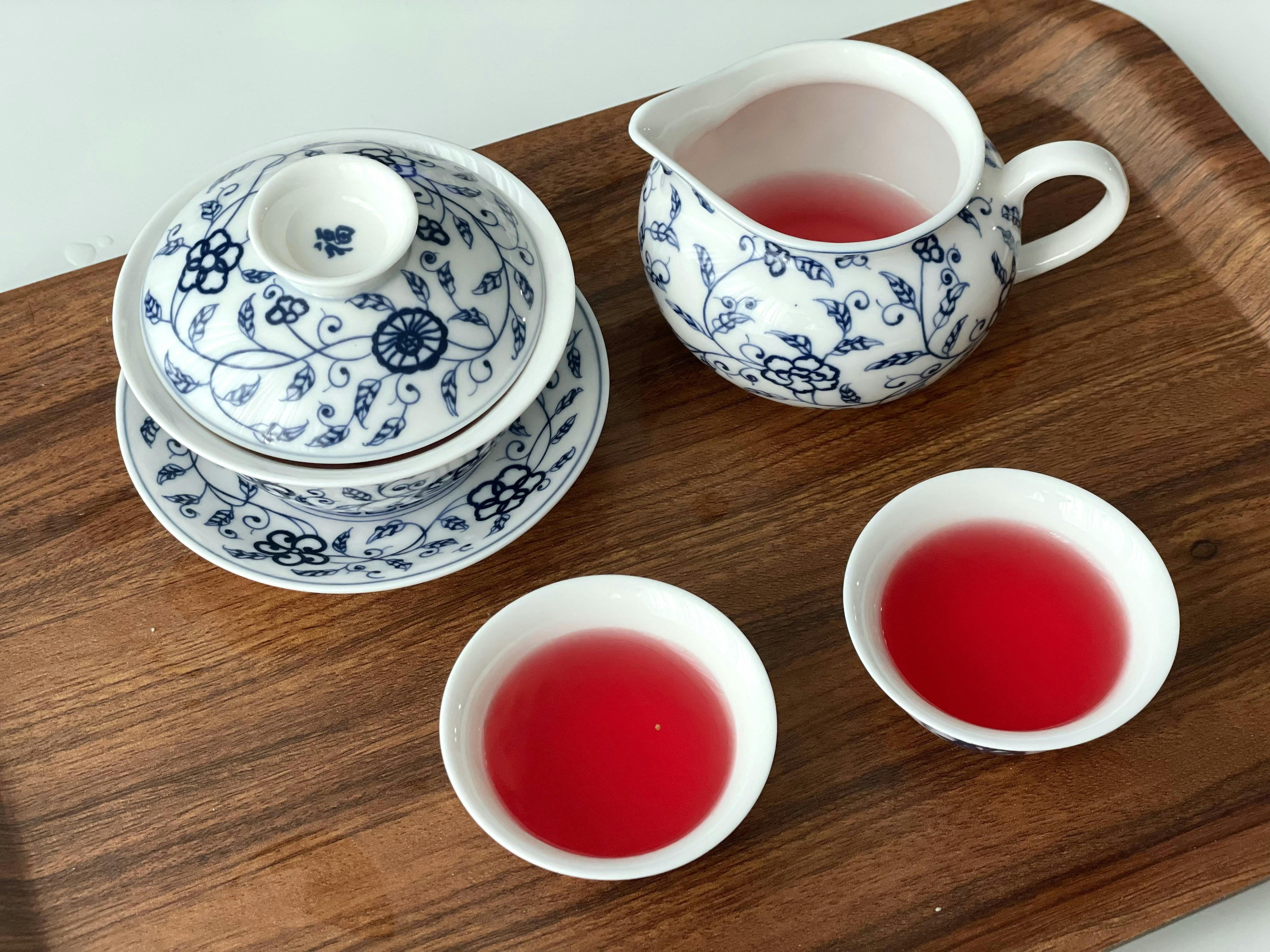 a wooden tray topped with two cups and a tea pot