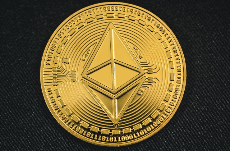A gold Ethereum coin placed on a dark surface