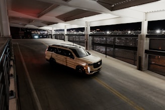 a van driving down a street next to a parking garage