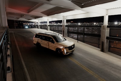 a van driving down a street next to a parking garage