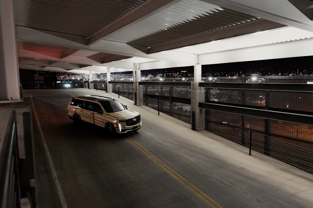 a car driving down a street next to a parking garage