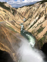 The dramatic Grand Canyon of Yellowstone with its colorful rock walls and roaring waterfall.