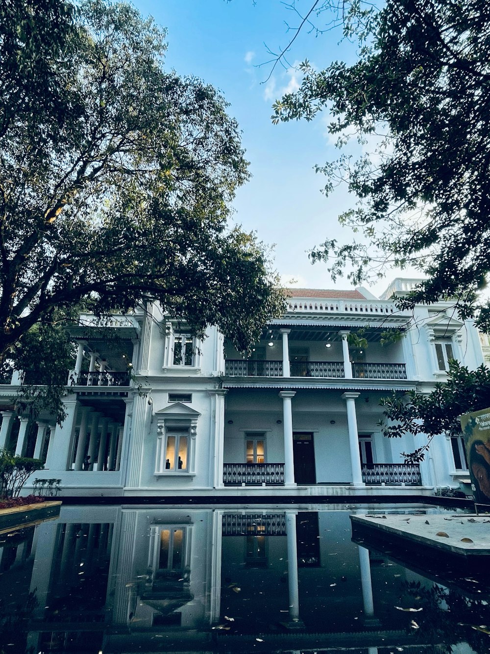 a large white house with a pool in front of it