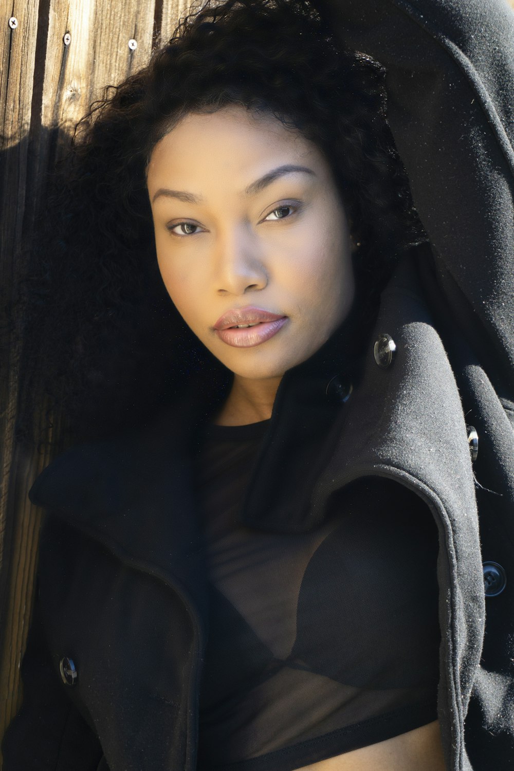 a woman in a black shirt and coat posing for a picture