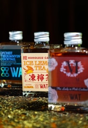 three bottles of tea sitting on top of a counter