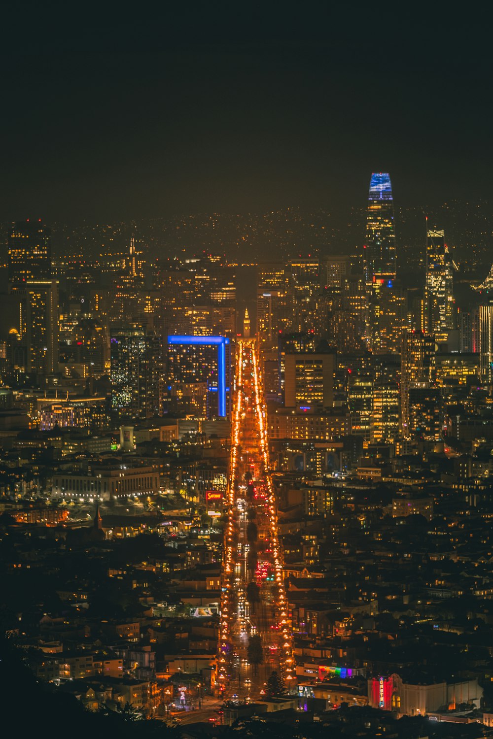 a view of a city at night from the top of a hill