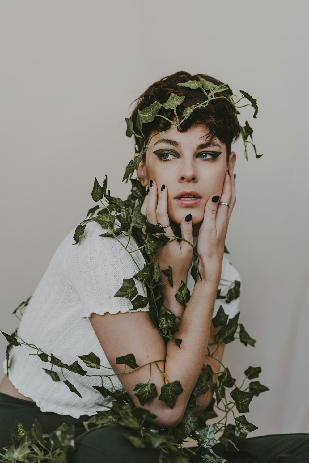 a woman with green leaves around her neck