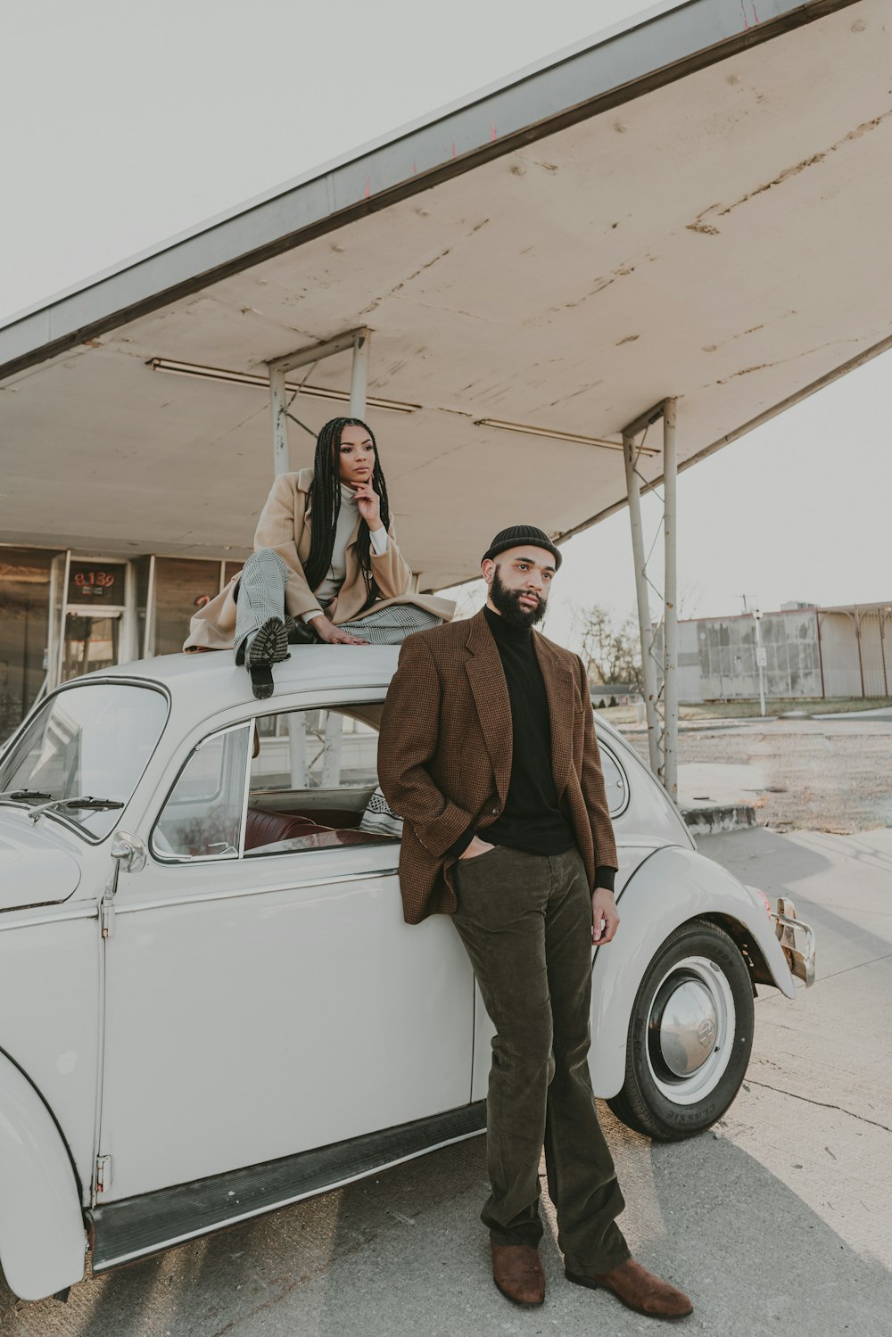 a man and a woman standing on top of a car