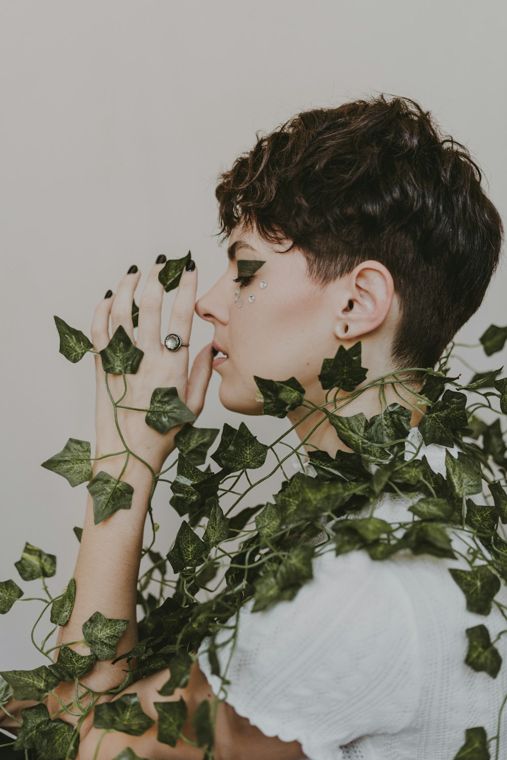 a woman with green leaves covering her face