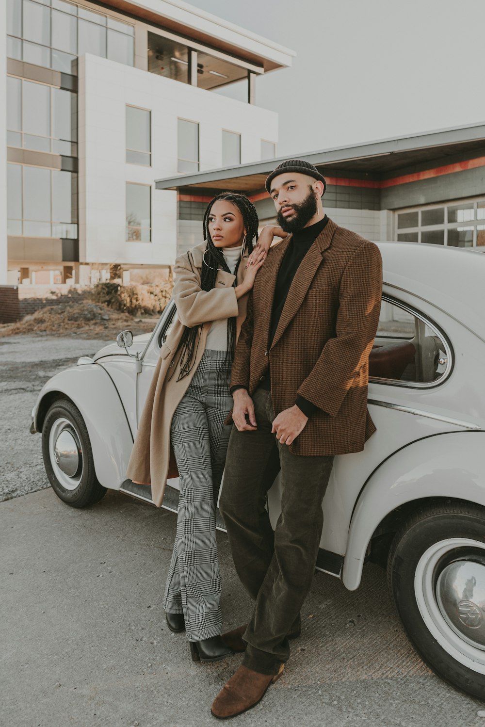 a man and a woman standing next to a car