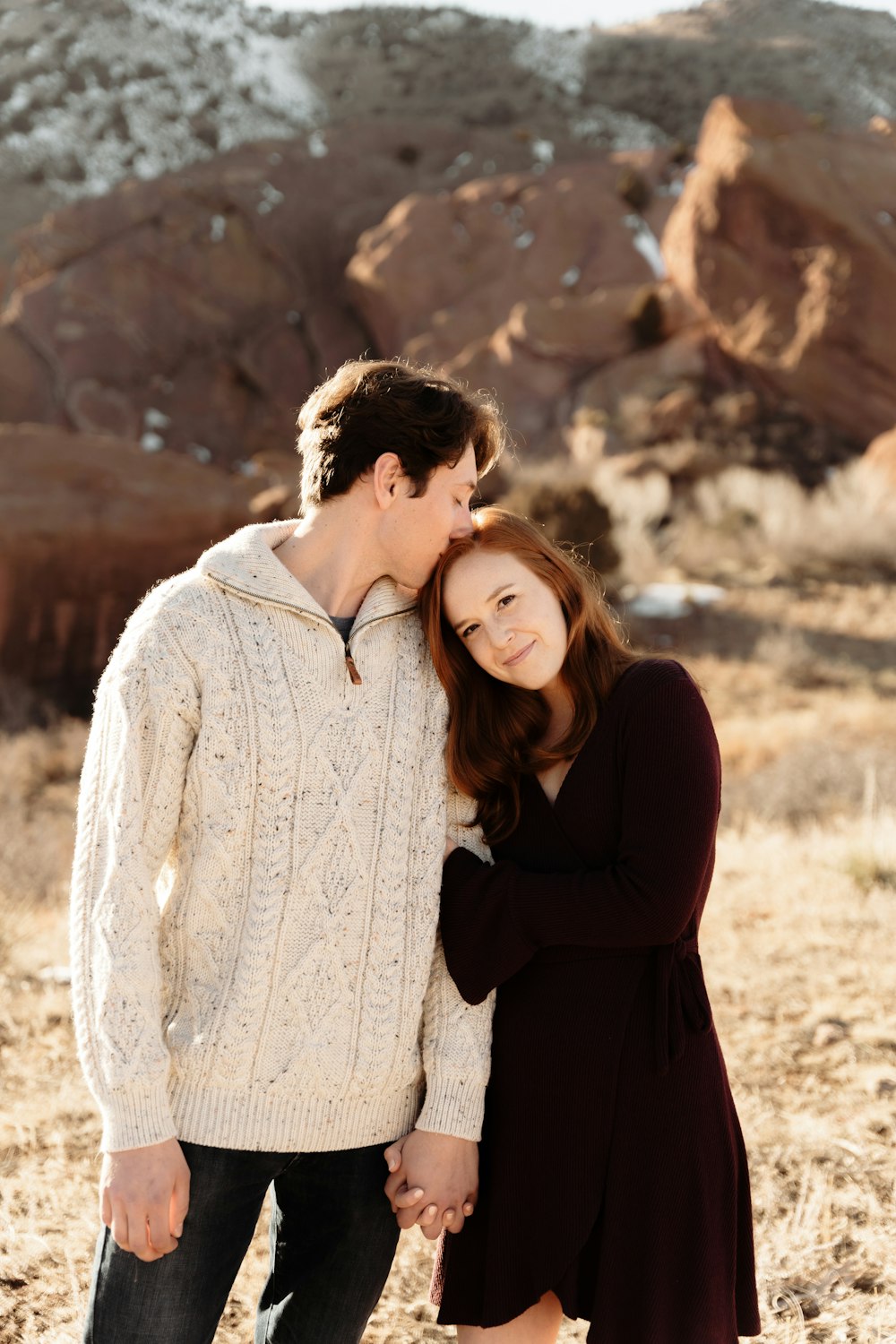 a man and a woman holding hands in the desert