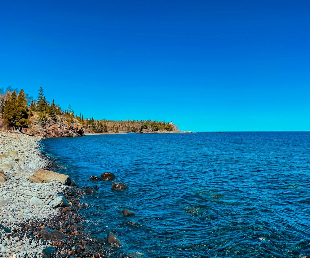 a rocky shore with a body of water next to it