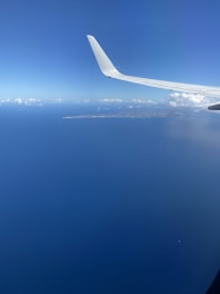 the wing of an airplane flying over the ocean